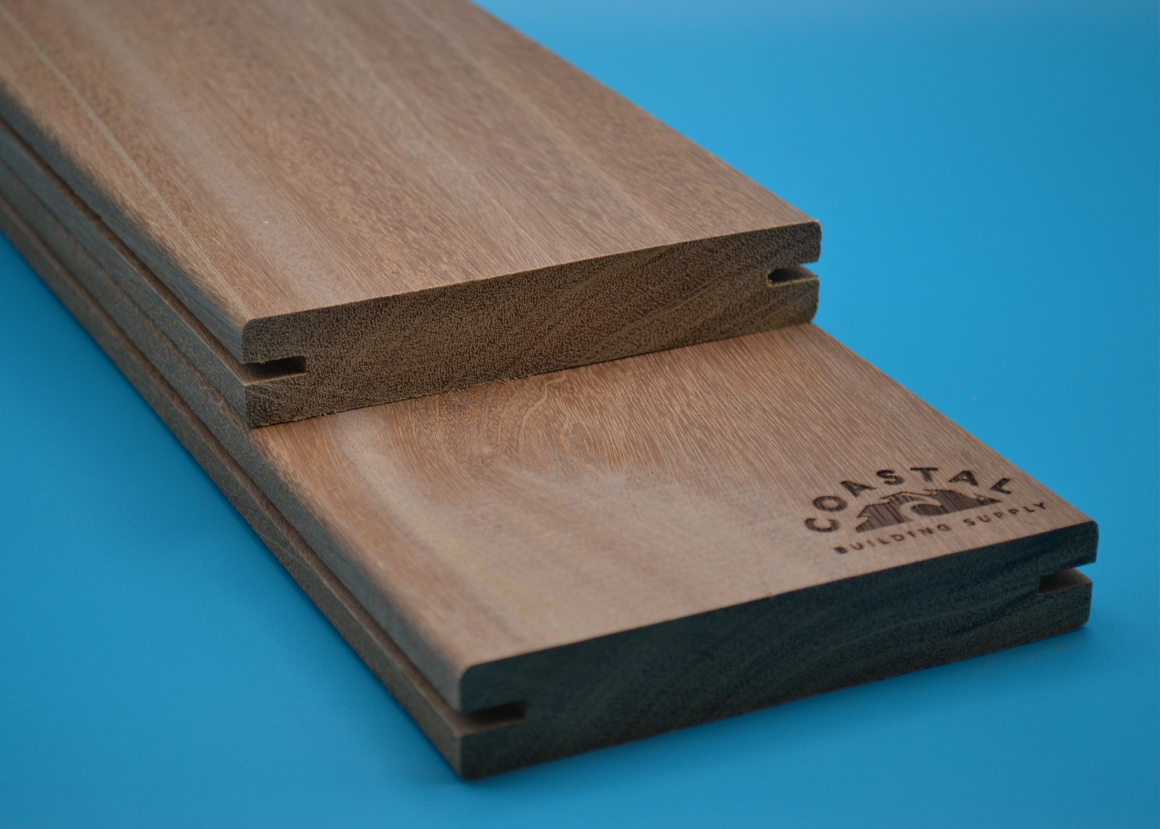 Yellow Balau 5/4x6 E4E Grooved Decking Planks on blue background