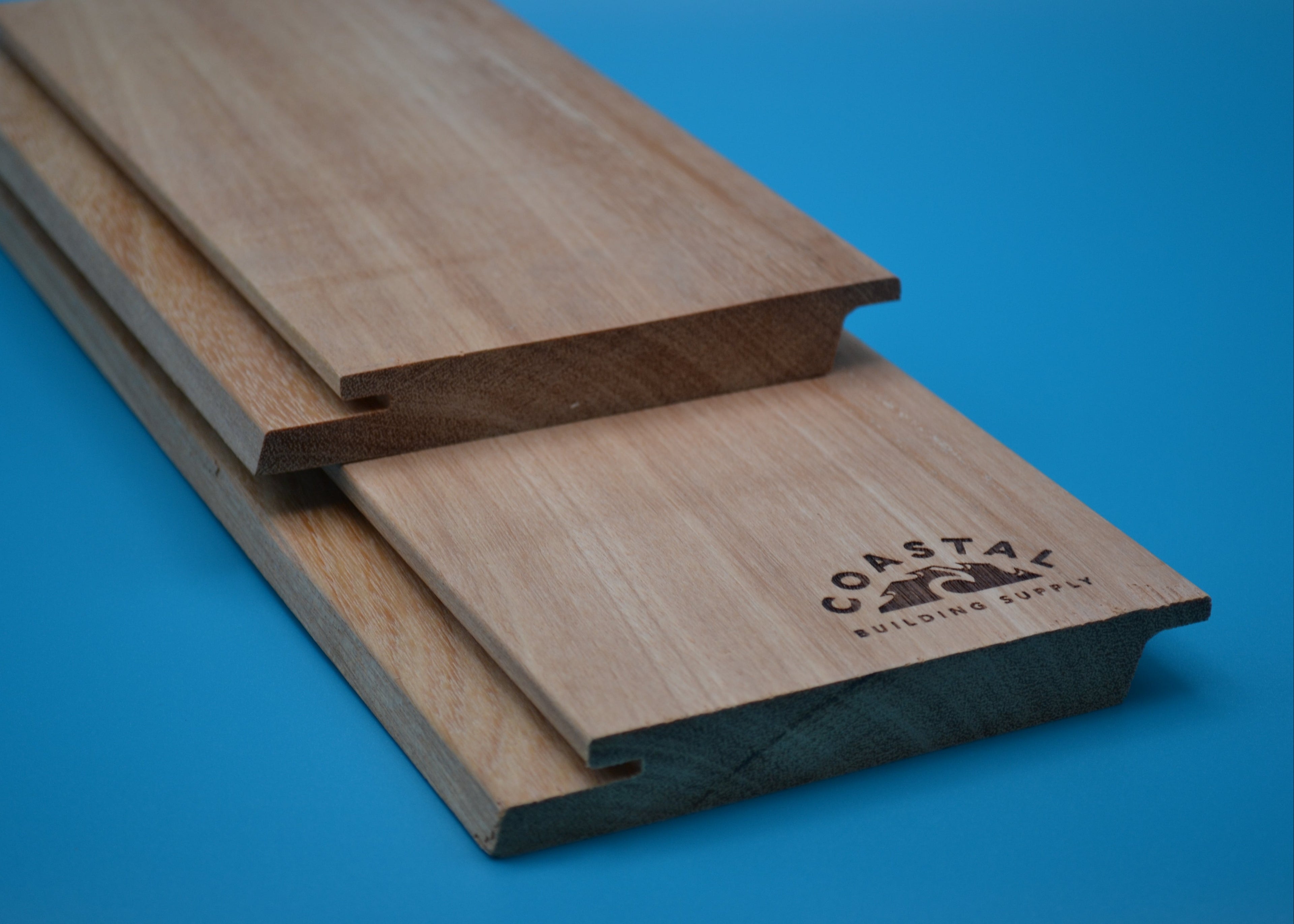 Yellow Balau 1x6 Rainscreen Planks on blue background