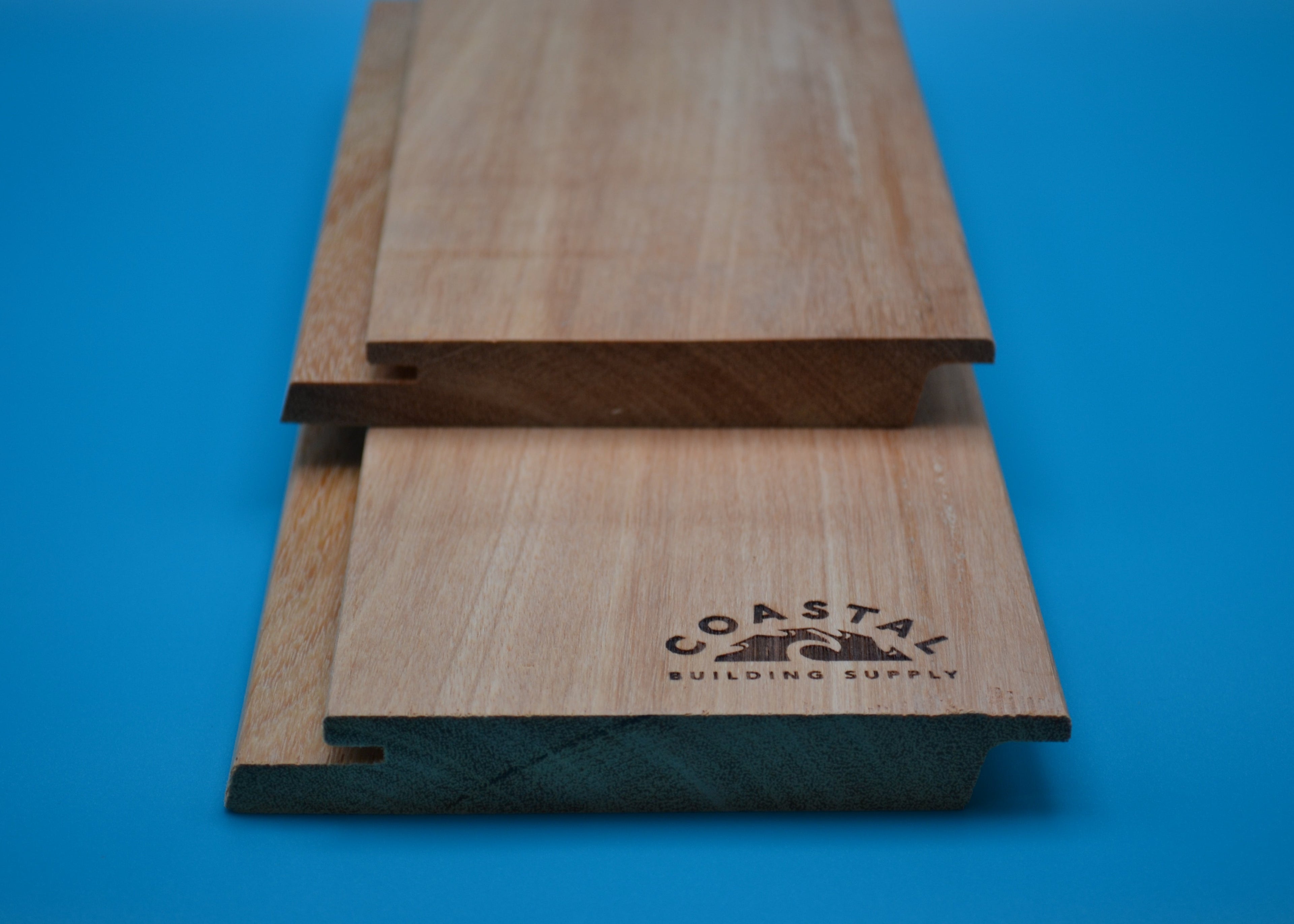 Yellow Balau 1x6 Rainscreen Planks on blue background
